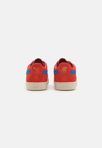 Røde ruskinds sneakers med blå accenter og beige gummisål. Har logodetaljer bagpå og en struktureret overflade.