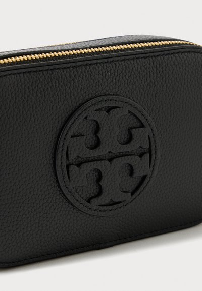 Pochete de couro texturizado preto com logotipo redondo em relevo e fecho dourado, contra um fundo claro e liso.