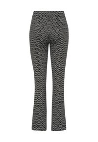Pantalon slim fit noir et blanc à motif losanges, jambes légèrement évasées et taille haute.