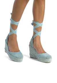 Sandali wedge espadrilles blu chiaro con fasce incrociate in tessuto, tacco in juta intrecciata texturizzata e punta arrotondata con un accento lavorato a maglia.