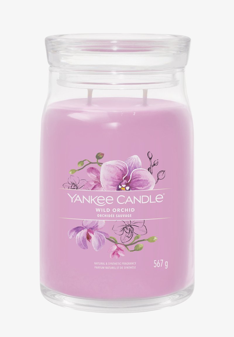 Large lilac candle in clear glass jar with two wicks, labeled "Yankee Candle Wild Orchid" featuring orchid flower illustrations.
