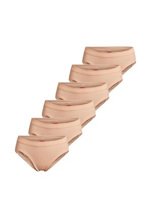 Sześć beżowych bawełnianych damskich majtek ułożonych przesunięcie na białym tle.
