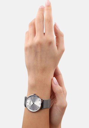 Silberne runde Armbanduhr mit einem Mesh-Armband. Sie verfügt über ein glattes, reflektierendes Zifferblatt mit minimalistischen Stundenmarkierungen und Branding.