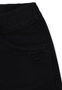 Pantaloni in denim nero con elastico in vita, dotati di una tasca frontale e un logo ricamato discreto sull'anca. Texture liscia.
