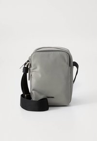 Graue Nylon-Umhängetasche mit Reißverschluss oben, verstellbarem schwarzem Riemen und minimalem Branding auf der Vorderseite. Flache rechteckige Form.