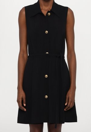 Czarna sukienka bez rękawów z kołnierzykiem, złotymi guzikami z przodu, paskiem w talii i gładką teksturą materiału.