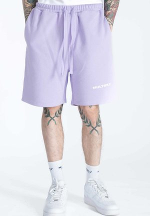 Purple cotton shorts with an elastic waistband and drawstring. Features a white “MULTIPLY” logo on the front. Worn with white sneakers.