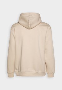 Felpa con cappuccio beige dalla texture liscia. Presenta un design semplice, polsini a coste e una tasca a marsupio, con una cucitura visibile sul cappuccio.