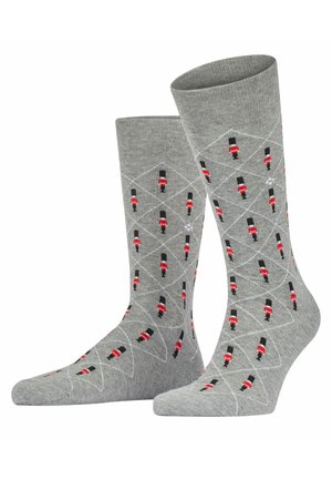 Graue Socken mit einem Rautenmuster, das kleine rote und schwarze Spielzeugsoldatendesigns zeigt, hergestellt aus einem weichen, strukturierten Material.