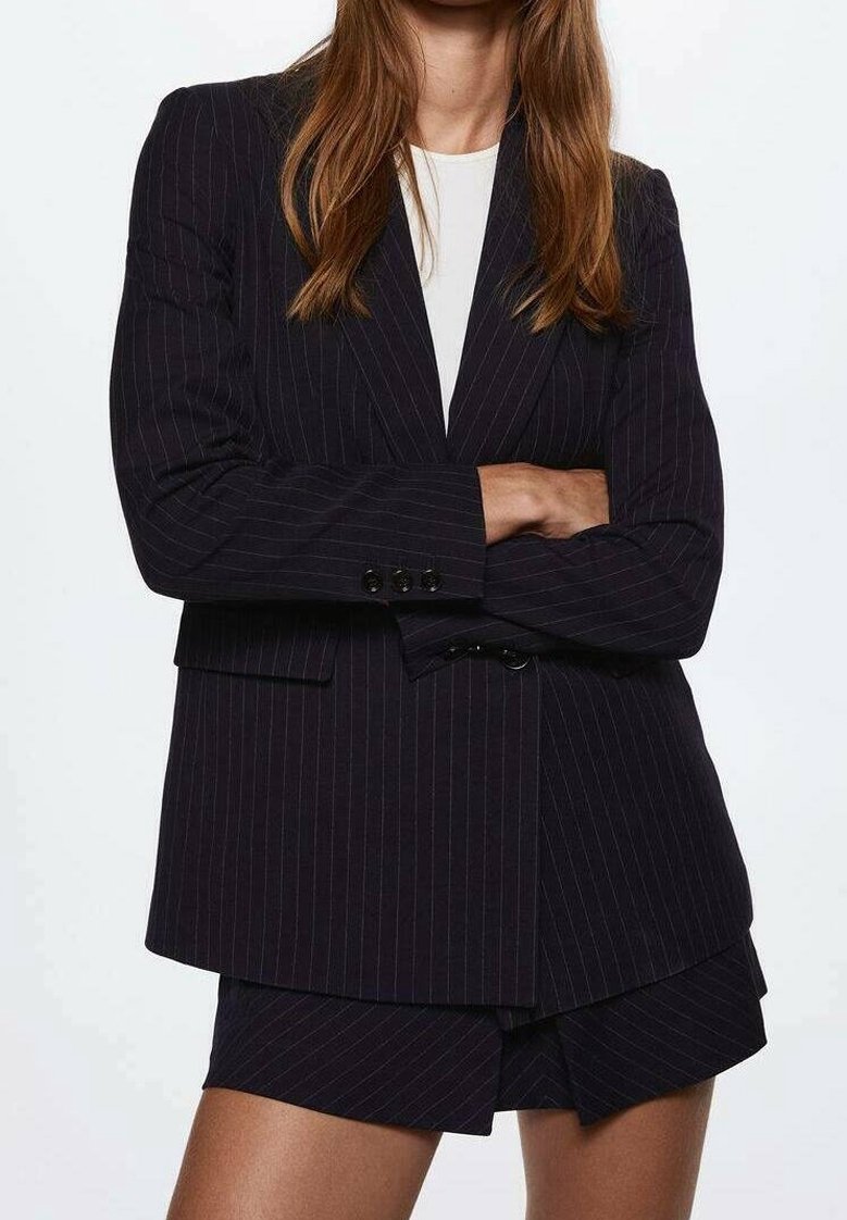 Námorně modrý pruhovaný blejzr s volným střihem, který má dvoubotnové zapínání, tenké klopy a patkové kapsy, spárovaný s odpovídajícími šortkami.