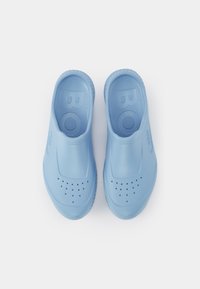 Tamancos azul claro feitos de um material suave e flexível. Apresentam orifícios de ventilação na área do dedo do pé e solas texturizadas para conforto.