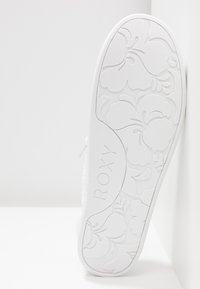 White shoe sole with floral pattern and "ROXY" logo; textured surface, rounded shape, smooth edges, and solid material design.