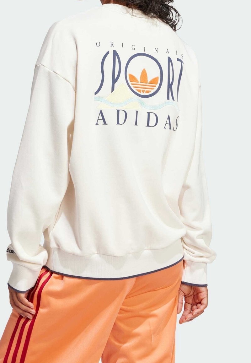 Cream sweatshirt with a large graphic reading "SPORT" and "ADIDAS" on the back, paired with orange track pants featuring red stripes.