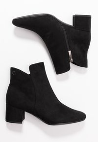 Černé kotníkové boty vyrobené z semiše s špičatou špičkou, bočním zipem a blokovým podpatkem. Hladký povrch s výraznými švy.