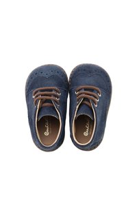 Zapatos de ante azul marino con punta redonda, que presentan cordones marrones, perforaciones decorativas a lo largo del empeine y un forro interior suave.