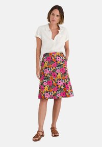 Floral skirt featuring vibrant pink, orange, and yellow flowers on a dark background. A-line shape, knee-length, with side pockets.