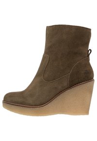 Stivaletto alla caviglia in camoscio marrone con tacco a zeppa, caratterizzato da una texture liscia, design curvo e un logo discreto sul tallone.