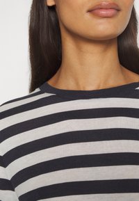 Gestreiftes Hemd mit horizontalen navyblauen und weißen Streifen, klassischem Rundhalsausschnitt und weicher Baumwolltextur.