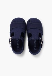 Navy canvas sandals with closed toe design, elastic straps, and silver buckle detail. Lightweight and flexible for comfort.