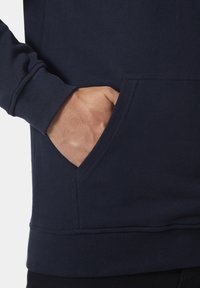Sudadera azul marino con bolsillo tipo canguro y puños acanalados. Fabricada en una suave tela de textura lisa y con costuras duraderas.