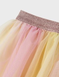 Ker skirt tulle bertumpuk dengan ikat pinggang berwarna emas mawar berkilau. Memiliki warna pastel: pink lembut, kuning, dan persik muda dalam kain transparan yang ringan.