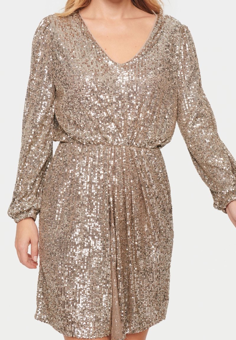 Paljetklänning i metallisk guld, med V-ringning, långa ärmar och elastisk midja för en avslappnad passform. Slät textur, glänsande yta.