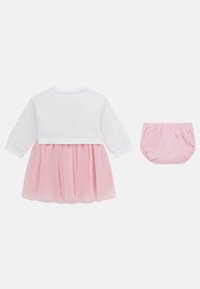 Valkoinen pitkähiha toppi vaaleanpunaisella tyllihameella, jossa on kootut vyötärö. Mukana on yhdistelevät vaaleanpunaiset bloomers-shortsit. Pehmeää kangasta ja joustava vyötärö.