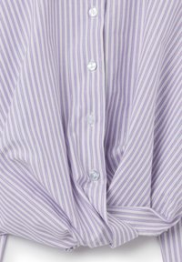Camicia button-up di un leggero color viola, con strisce bianche verticali, tessuto liscio e un dettaglio annodato sul davanti. Sei bottoni visibili.