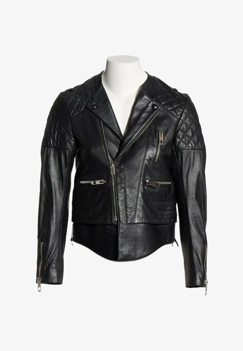 Veste de motard en cuir noir avec épaules matelassées, fermeture éclair frontale asymétrique, poches zippées et poignets zippés sur un torse de mannequin blanc.