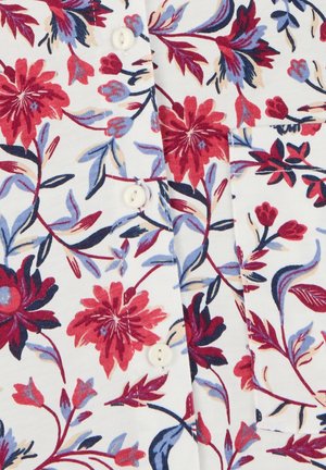 Tessuto bianco con un motivo floreale rosso e viola, con bottoni bianchi e una tasca frontale cucita sulla camicia.