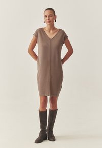 Braunes Strickkleid mit V-Ausschnitt, kurzen Ärmeln und gerader Silhouette. Verfügt über eine zentrale Naht und einen Saum, der knapp über dem Knie endet.