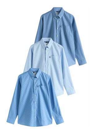 Three long-sleeve shirts in varying shades of blue: solid light blue, solid medium blue, and patterned dark blue with small dots. Each has a collar and a pocket.