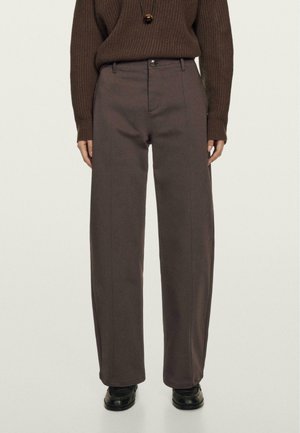 Brown ribbed sweater paired with high-waisted, wide-leg gray pants featuring front seams, a button closure, and a smooth texture.