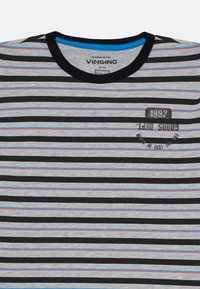 T-shirt a righe con strisce orizzontali nere, grigie e blu. Presenta un collo rotondo e testo stampato con "1997" e accenti "per amore di...".