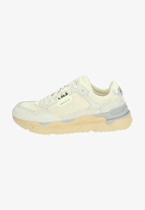 Cream-colored sneaker with mesh upper and suede accents; features a chunky beige sole, grey detailing, and branding on the side.