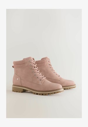 Růžové semišové kotníkové boty s žebrovaným límcem, kovovými očky a pevným béžovým gumovým podpatkem se strukturovaným vzorem.