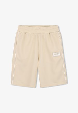 Shorts de sport beiges en tissu texturé, dotés d'une taille élastique, de rayures blanches latérales et d'un écusson logo sur le côté gauche.