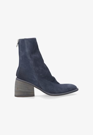 Dunkelblaue Wildleder-Stiefeletten mit durchbrochenem Design, Reißverschluss und Blockabsatz mit strukturiertem Holzfinish.