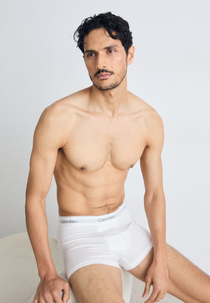 Boxer-briefs blancs en coton de Calvin Klein, avec une taille douce. Le tissu est lisse avec un léger élasticité, ajusté autour des cuisses.