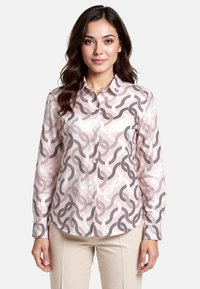 Long-sleeve button-up shirt in pastel pink featuring an abstract chain pattern in dark gray and white. Soft fabric with collar and cuffs.