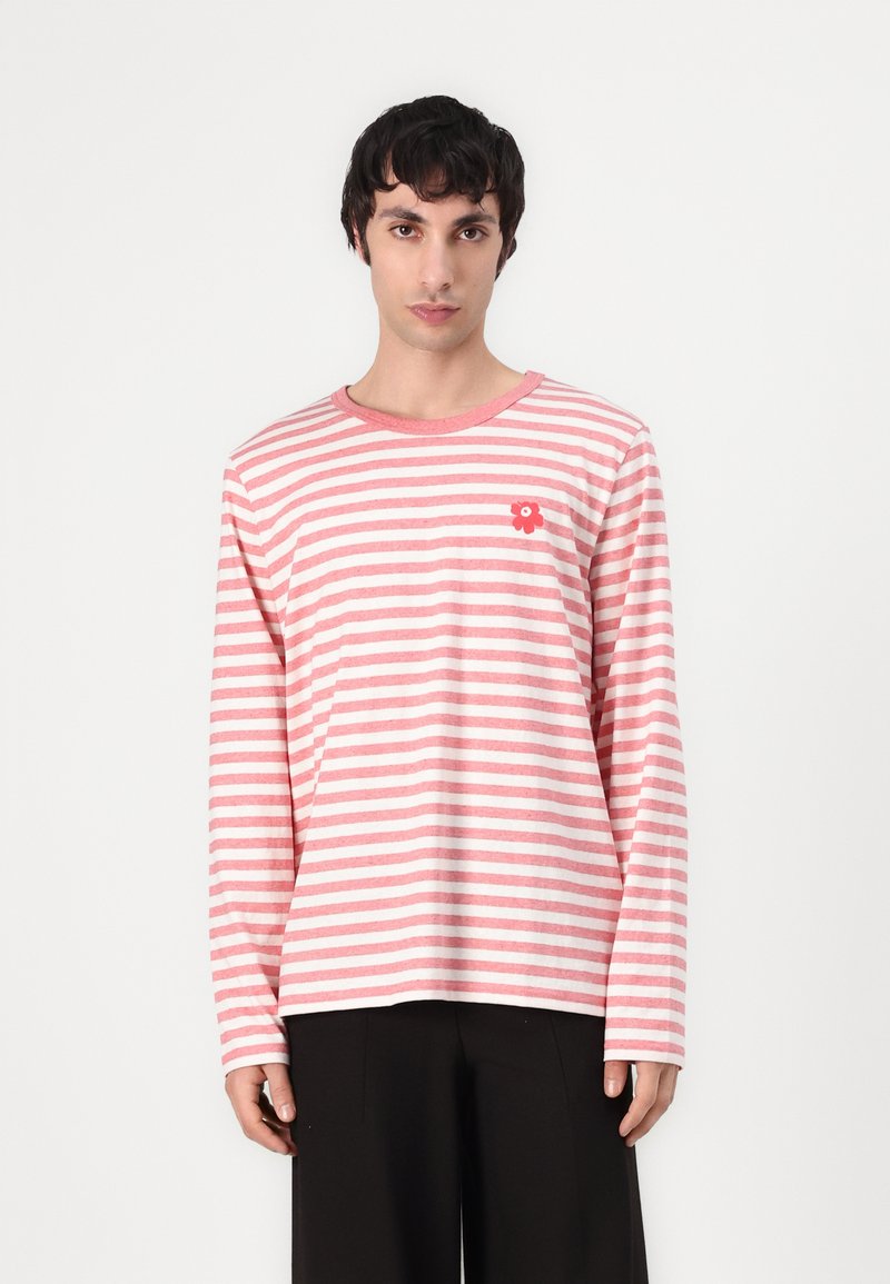 Rožių ir baltos spalvos dryžuotas marškinėliai ilgomis rankovėmis pagaminti iš medvilnės, su apvalia iškirpte ir mažom raudonom gėlių siuvinėtomis detalėmis ant krūtinės.