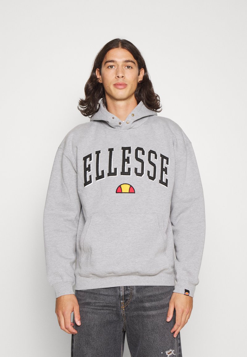 Grijze hoodie met een voorzak in kangoeroestijl, zwart "ELLESSE" logo en gekleurd embleem. De stof lijkt zacht met ribgebreide manchetten en onderrand.