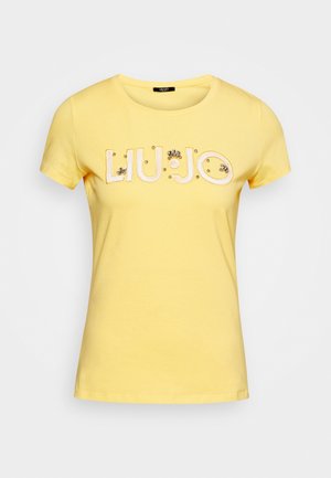 Gul t-shirt med korte ærmer og 'LIU·JO'-bogstaver pyntet med perler tværs over brystet.