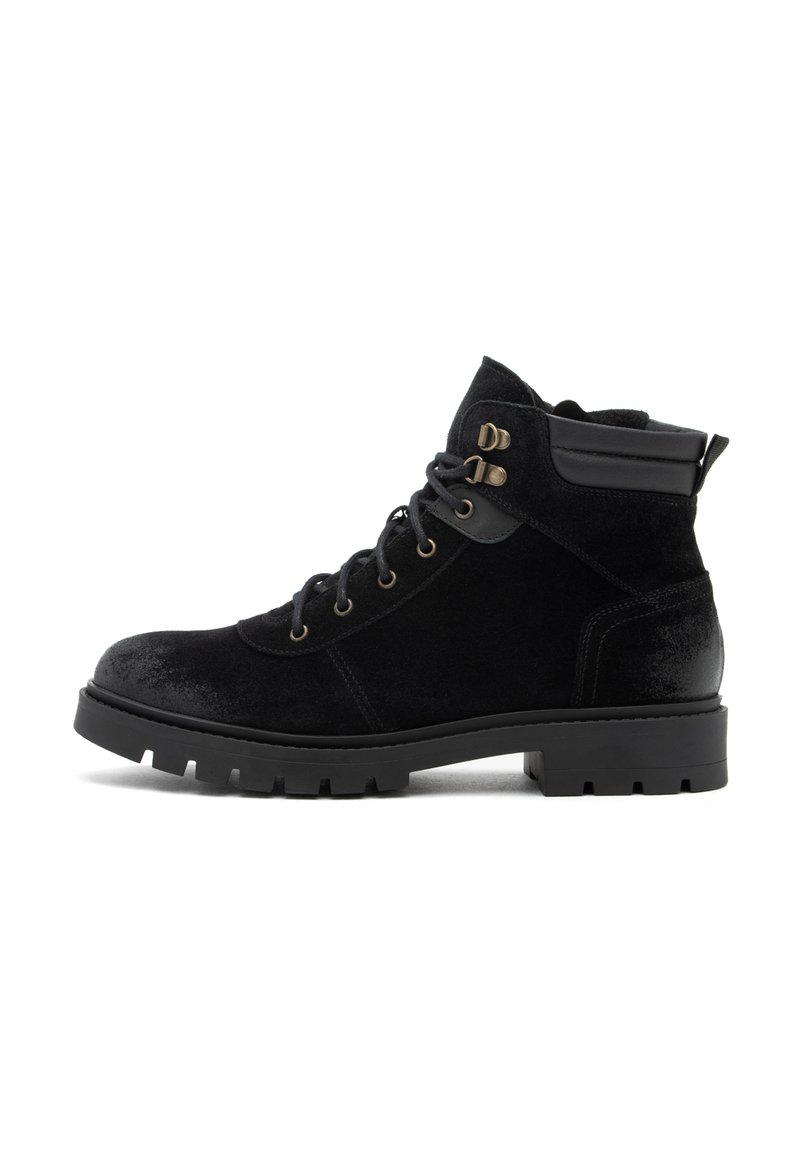 Botas negras hasta el tobillo hechas de ante y cuero, con ojales de metal, una parte superior texturizada y una suela de goma resistente con surcos.