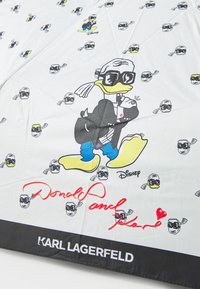Bijela tkanina s karikaturama Donalda Ducka u naočalama. Crni i žuti naglasci, s potpisom u crvenoj boji. Brand oznaka na dnu.