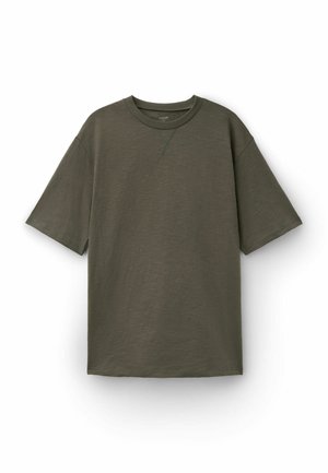 Short-sleeve olive green crewneck T-shirt with ribbed collar and stitched V detail below neckline, laid flat on white background.