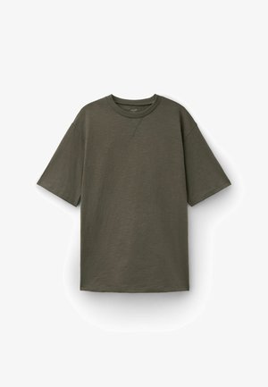 Olivegrünes T-Shirt mit kurzen Ärmeln, Rundhalsausschnitt mit Rippstrickkragen und gestepptem V-förmigem Detail unter dem Halsausschnitt, flach auf weißem Hintergrund liegend.