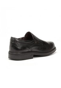 Zapato de cuero negro con un acabado liso, diseño sin cordones, punta redondeada, tacón bajo y detalles de costura delgada en los lados.