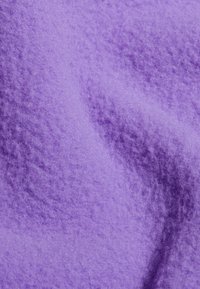Paarse stof met een zachte, textuurachtige oppervlakte en een licht glanzende afwerking. Het materiaal lijkt pluizig met subtiele variaties in tint.