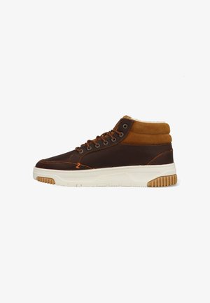 Bruine hoge sneakers met een bovenwerk van leer en suede, een witte rubberen zool en een tan fleece voering bij de enkel.